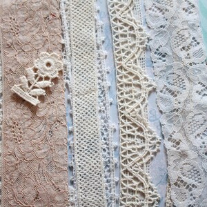 May include: Assortment of white and cream lace trims with various patterns and textures. The lace trims are arranged in a vertical row.