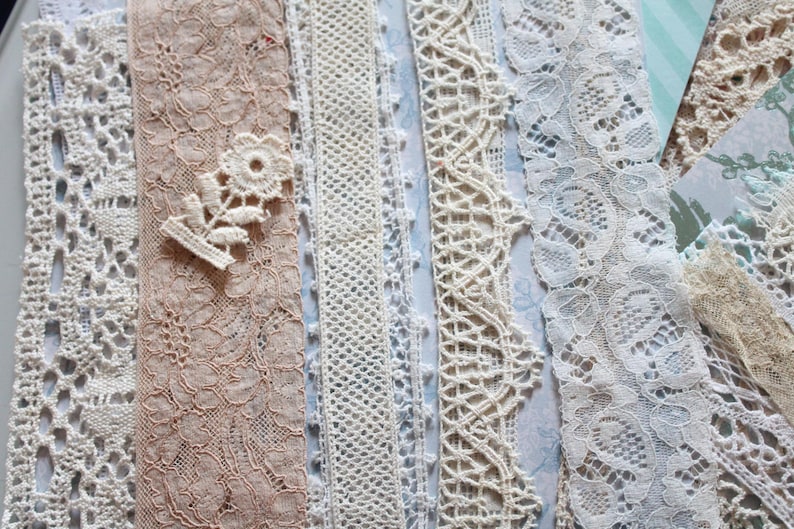 May include: Assortment of white and cream lace trims with various patterns and textures. The lace trims are arranged in a vertical row.
