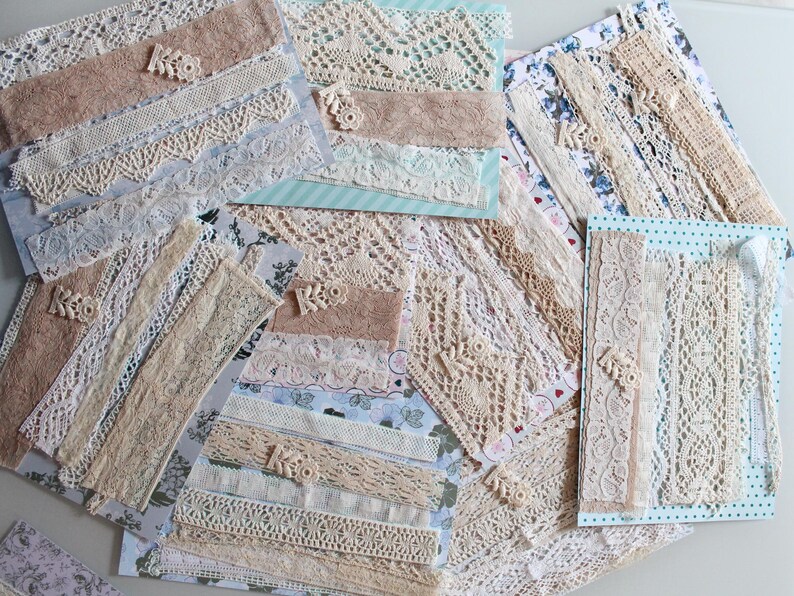 May include: Assortment of white and cream lace trim, some with a delicate floral pattern, arranged on a white surface.