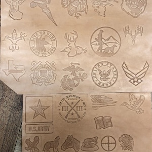 May include: A brown leather sheet with various designs and logos, including a turkey, a deer, a bear, a pheasant, a star, a cross, a duck, a snake, a target, and an eagle. The text "LIVE TO HUNT HUNT TO LIVE" is also visible.