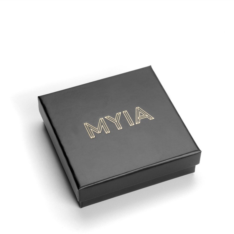 May include: A black square box with the word "MYIA" printed in gold lettering.