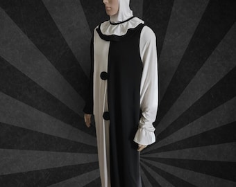 May include: A long-sleeved, floor-length garment featuring a split black and white color-blocked design. It includes a white hood, a ruffled collar with black trim, two large black circular buttons on the front, and ruffled cuffs at the wrists.