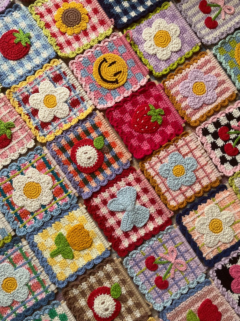 K&ouml;nnte beinhalten: Eine Sammlung farbenfroher, geh&auml;kelter Untersetzer mit verschiedenen Designs. Jeder quadratische Untersetzer zeigt ein anderes Motiv, darunter Blumen, Fr&uuml;chte und ein Smiley. Die Untersetzer haben gewellte Kanten und sind in einem Raster angeordnet.