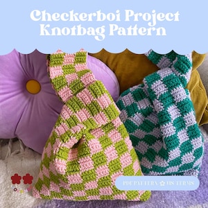 May include: Two handmade checkerboard knot bags in green and pink, and green and purple. The bags are made of a soft, textured yarn. The image also includes a purple flower-shaped pillow and the text "Checkerboi Project Knotbag Pattern".