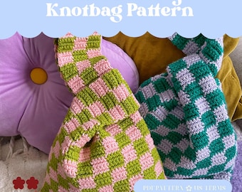 May include: Two handmade checkerboard knot bags in green and pink, and green and purple. The bags are made of a soft, textured yarn. The image also includes a purple flower-shaped cushion and the text "Checkerboi Project Knotbag Pattern".