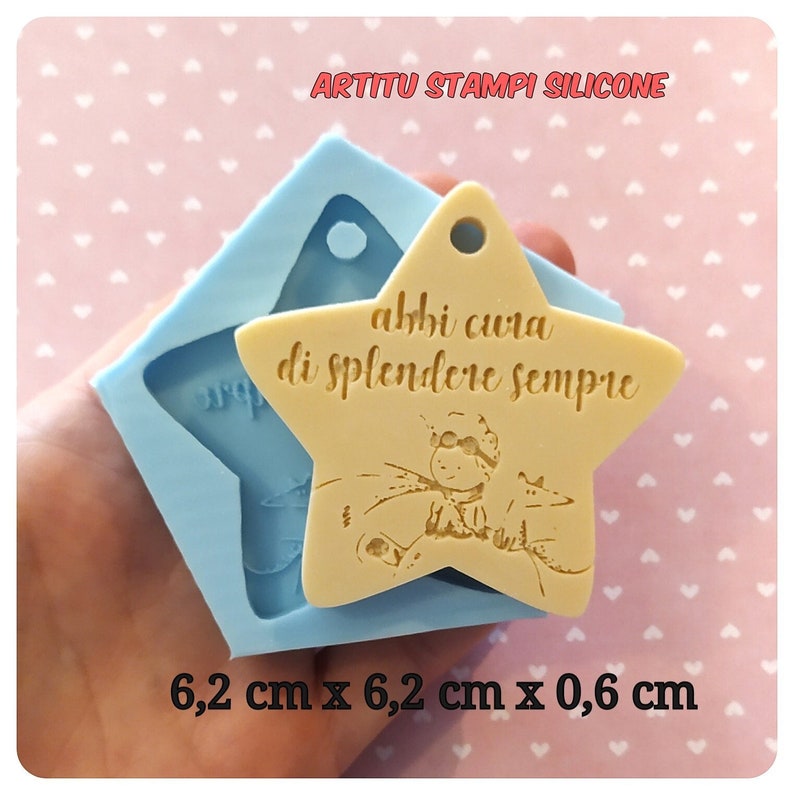 Stampo in silicone per riprodurre stella con incisione figura piccolo principe con volpe, e scritta abbi cura di splendere sempre. Stella con buco per agganciare a bomboniera o decorare con fiocco. Vicino a stampo, creazione in resina come esempio.