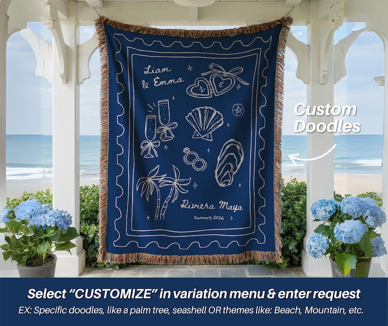 May include: A navy blue throw blanket with white custom doodles, including champagne flutes, seashells, and palm trees. The blanket has a fringed edge and the text "Liam & Emma" and "Riviera Maya January 2026". The text "Custom Doodles" is also visible.