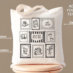 K&ouml;nnte beinhalten: Eine wei&szlig;e Canvas-Tragetasche mit schwarz-wei&szlig;en Illustrationen, die Briefmarken &auml;hneln. Designs umfassen B&uuml;cher, Kaffee, Blumen und den Text "Book Club Name Here" und "New York City". Die Tasche hat einen Griff und Platz zum Hinzuf&uuml;gen von Text.