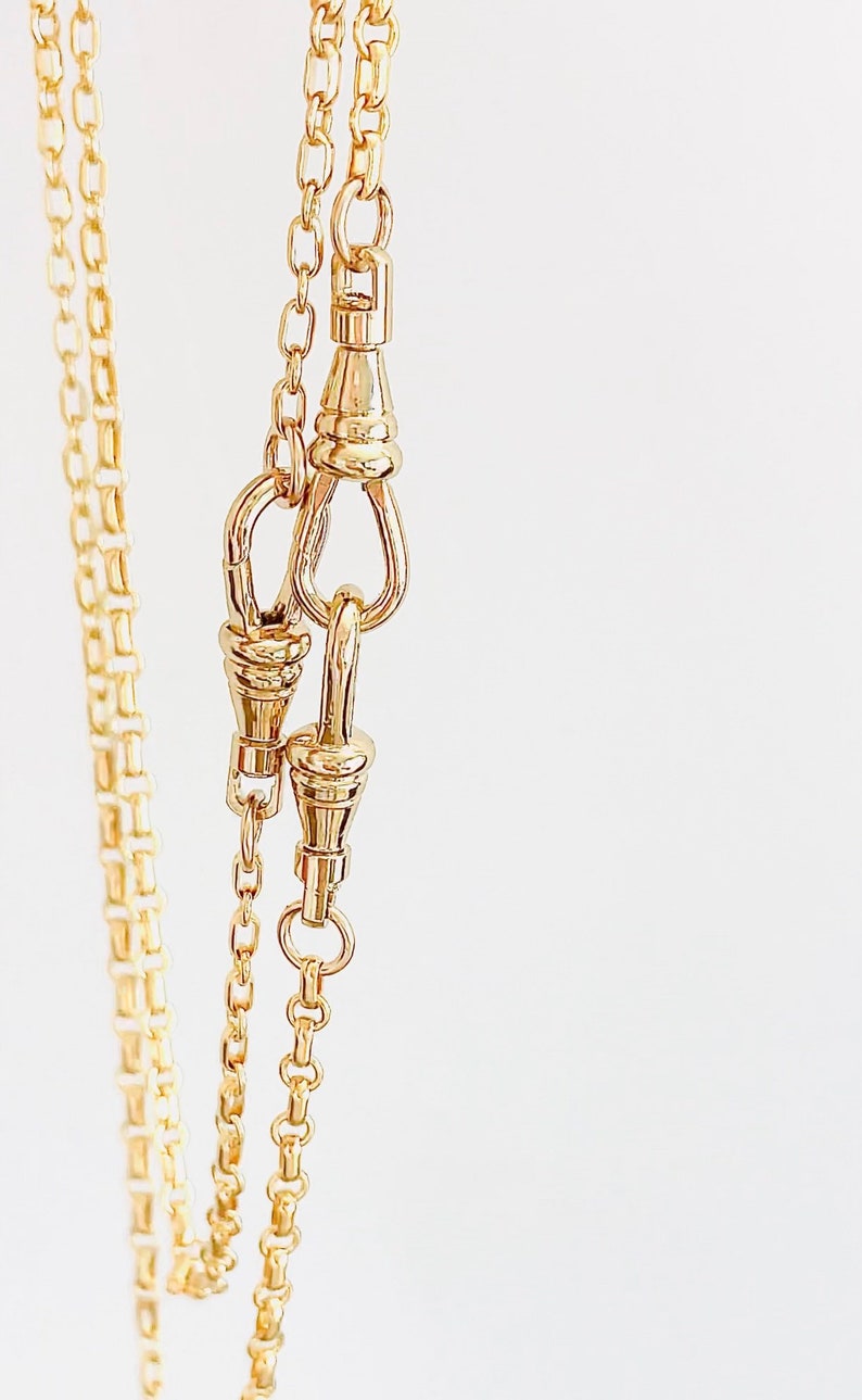 May include: A gold chain necklace with a lobster clasp closure. The chain is made of small, linked circles.