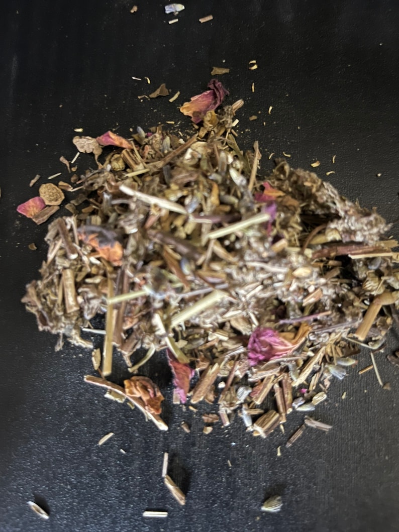 May include: A close-up of a pile of dried herbs and flower petals, including lavender, rose, and other botanicals. The herbs are a mix of brown, green, and purple.
