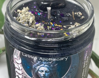 May include: Black candle jar with a black stone on top. The jar has a label that says "Le'ble Apothecary" and "Hecate" with a woman's face on it. The label also says "Sorcery | Nec" and "sroads".