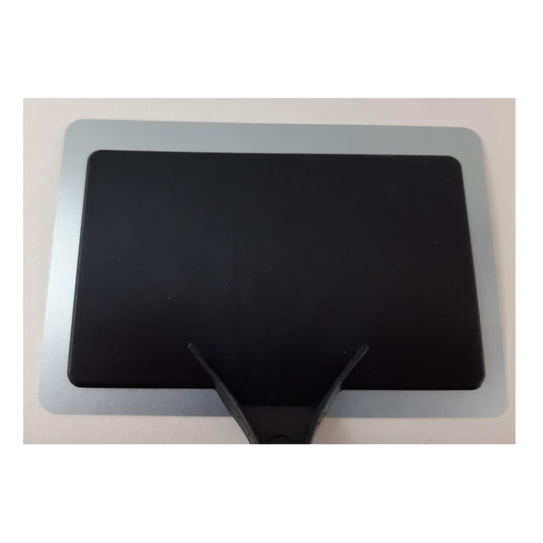 May include: A black dry erase board with a silver frame and a black plastic handle.