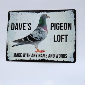 May include: A white metal sign with black text and a picture of a pigeon. The sign says "Dave's Pigeon Loft" and "Made with any name and words".