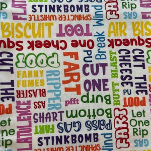 May include: White fabric with a colorful, repeating pattern of words like "Fart," "Stinkbomb," and "Poot" in various fonts and colors. The words are arranged in a random, overlapping design.