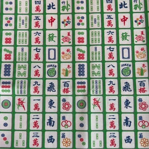 Pode incluir: Tecido verde com um padr&atilde;o repetido de pe&ccedil;as de Mahjong brancas. As pe&ccedil;as apresentam caracteres chineses, pontos e outros s&iacute;mbolos em vermelho, verde e azul. O fundo &eacute; verde liso.