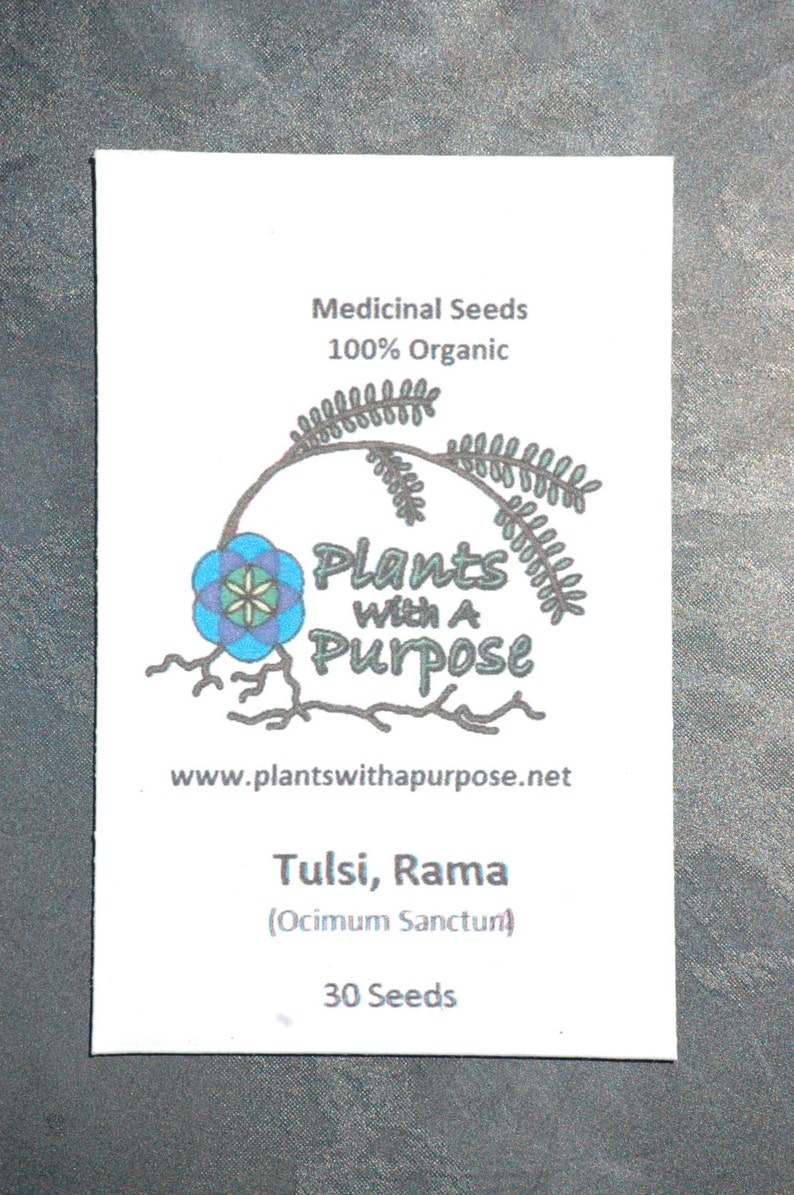 May include: A white packet of Tulsi, Rama (Ocimum Sanctum) seeds. The packet has a logo with a blue flower and the text "Plants with a Purpose" and the website address "www.plantswithapurpose.net". The packet contains 30 seeds.