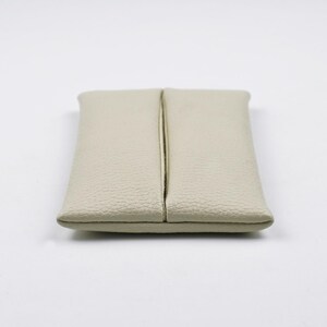 Pu&ograve; includere: Un porta fazzoletti rettangolare di colore beige, realizzato in materiale testurizzato. L'articolo presenta un'apertura verticale centrale che corre lungo tutta la lunghezza del pezzo, consentendo l'estrazione dei fazzoletti. I bordi sono cuciti.