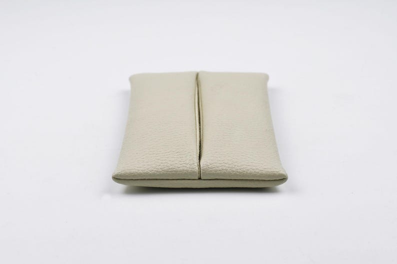 Pu&ograve; includere: Un porta fazzoletti rettangolare di colore beige, realizzato in materiale testurizzato. L'articolo presenta un'apertura verticale centrale che corre lungo tutta la lunghezza del pezzo, consentendo l'estrazione dei fazzoletti. I bordi sono cuciti.