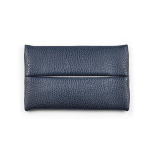 Pu&ograve; includere: Un porta fazzoletti rettangolare blu navy con una superficie testurizzata e granulosa. L'accessorio presenta una fessura orizzontale al centro, che consente di estrarre i fazzoletti dallo scomparto interno di questo oggetto compatto.