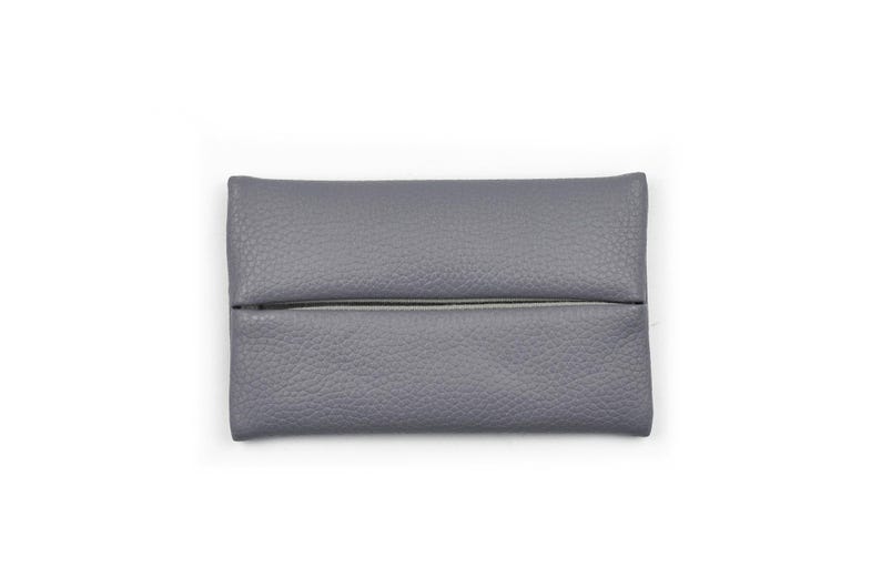 Pu&ograve; includere: Un porta fazzoletti rettangolare di colore grigio con una texture granulata. L'oggetto presenta una fessura orizzontale al centro che permette di estrarre i fazzoletti. Il design &egrave; semplice e funzionale, con un colore grigio uniforme.