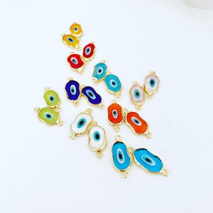 May include: Assortment of colorful evil eye charms with gold accents. The charms are oval shaped and have a blue eye in the center. They are perfect for jewelry making or adding a touch of protection to your crafts.