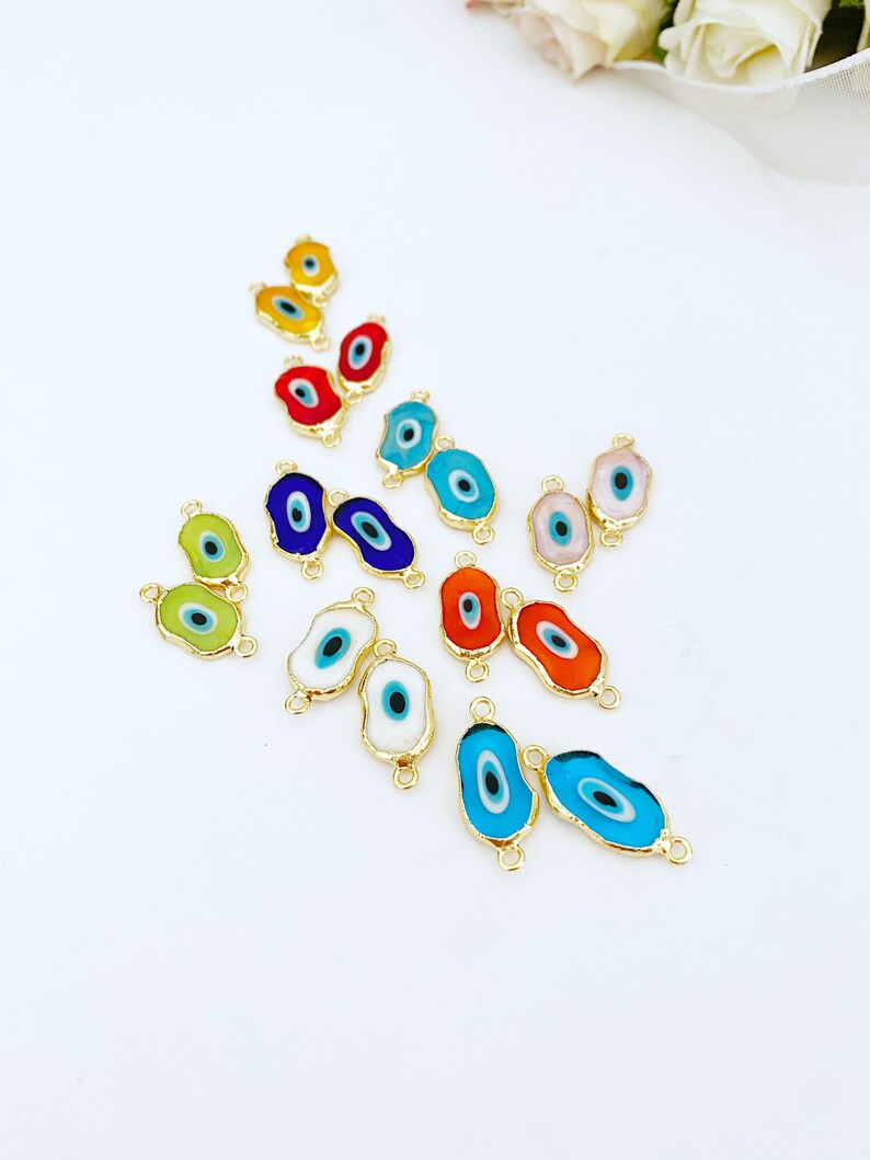 May include: Assortment of colorful evil eye charms with gold accents. The charms are oval shaped and have a blue eye in the center. They are perfect for jewelry making or adding a touch of protection to your crafts.
