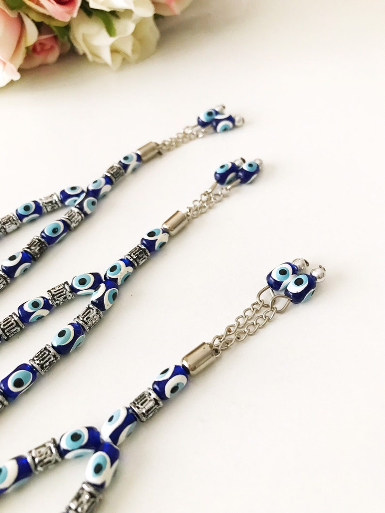 May include: Three blue and white evil eye bead necklaces with silver accents and chain attachments.