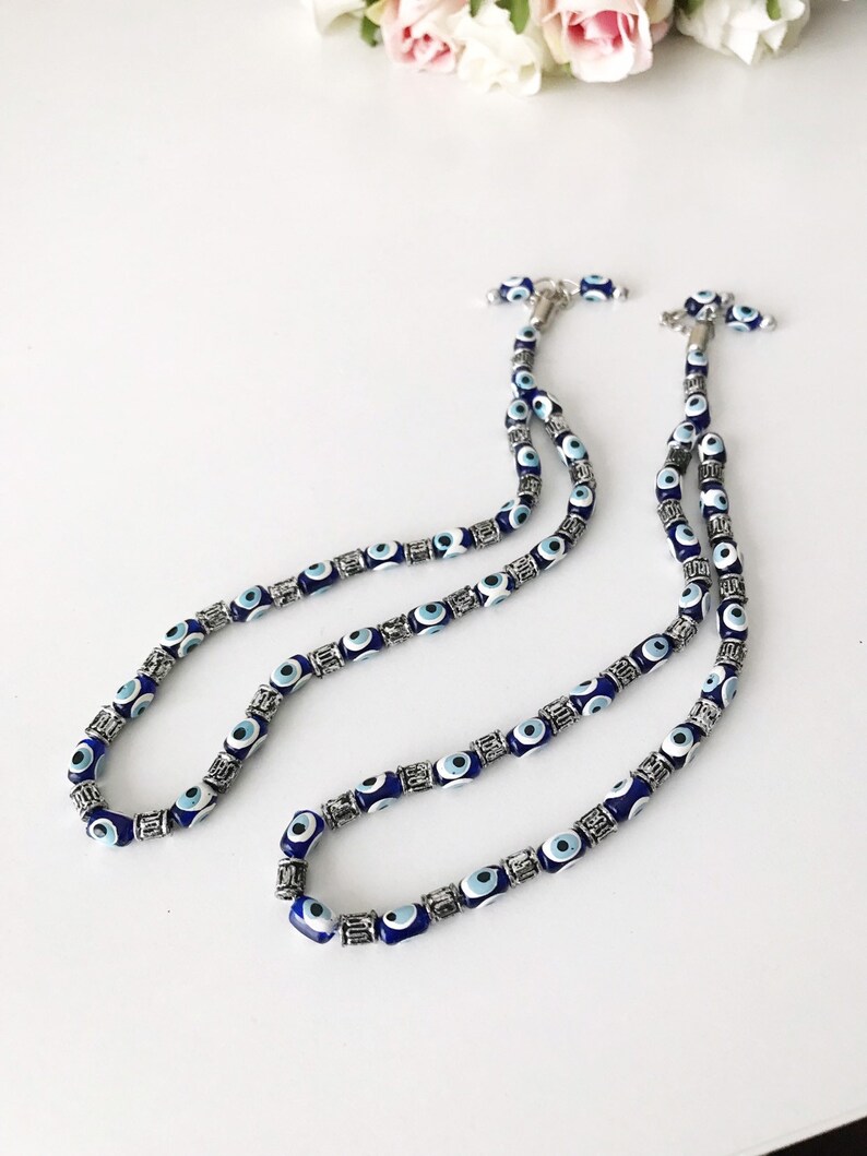May include: A double strand necklace with blue and white evil eye beads and silver accents.