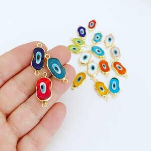 May include: Assortment of colorful evil eye charms with gold-toned metal accents. The charms are shaped like an oval with a blue eye in the center. The charms are perfect for adding a touch of protection and good luck to jewelry, keychains, and other crafts.
