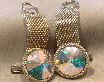 May include: A pair of gold-toned cufflinks. Each cufflink features a round, iridescent crystal center surrounded by a twisted rope design. The mesh-like metal band connects to a curved loop.