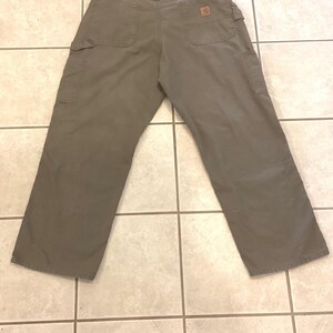 Puede incluir: Pantalones de trabajo verde oliva con m&uacute;ltiples bolsillos, incluyendo dos bolsillos traseros y dos bolsillos laterales. Los pantalones tienen un parche cuadrado marr&oacute;n con el logo en el bolsillo trasero. Los pantalones est&aacute;n hechos de un material duradero.