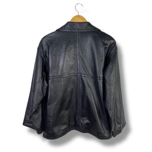 May include: A black leather jacket with a zipper closure and a collar. The jacket has a seam down the center of the back and a seam across the shoulders.