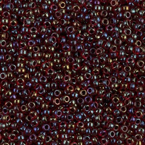 May include: A close-up view of a large quantity of small, round, red glass beads with an iridescent finish.