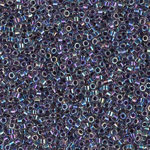 May include: A close-up image of a large quantity of small, round, iridescent glass beads. The beads are a mix of purple, blue, and silver colours.