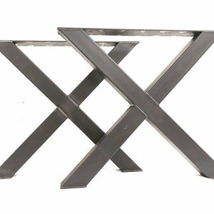 May include: A pair of black metal table legs in an X shape. The legs are made of thick, sturdy metal and are designed to support a table top.