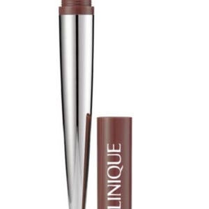 May include: A Clinique cosmetic applicator with a silver metallic tapered body and a brown base. The top features a black foam sponge tip. The matching brown cylindrical cap is positioned next to the applicator, displaying the brand name Clinique.