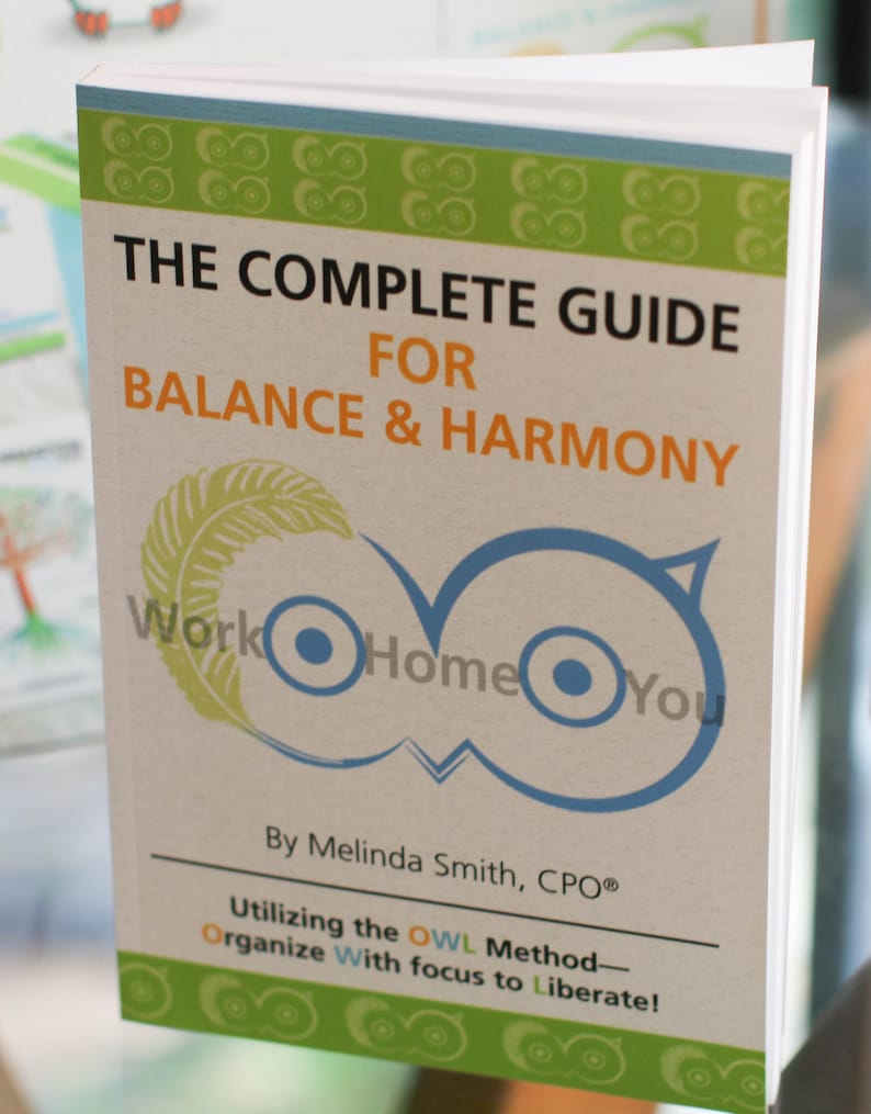 May include: A green and white book titled "The Complete Guide for Balance & Harmony" with the text "Work Home You" and "By Melinda Smith, CPO&reg;" and "Utilizing the OWL Method - Organize With focus to Liberate!"