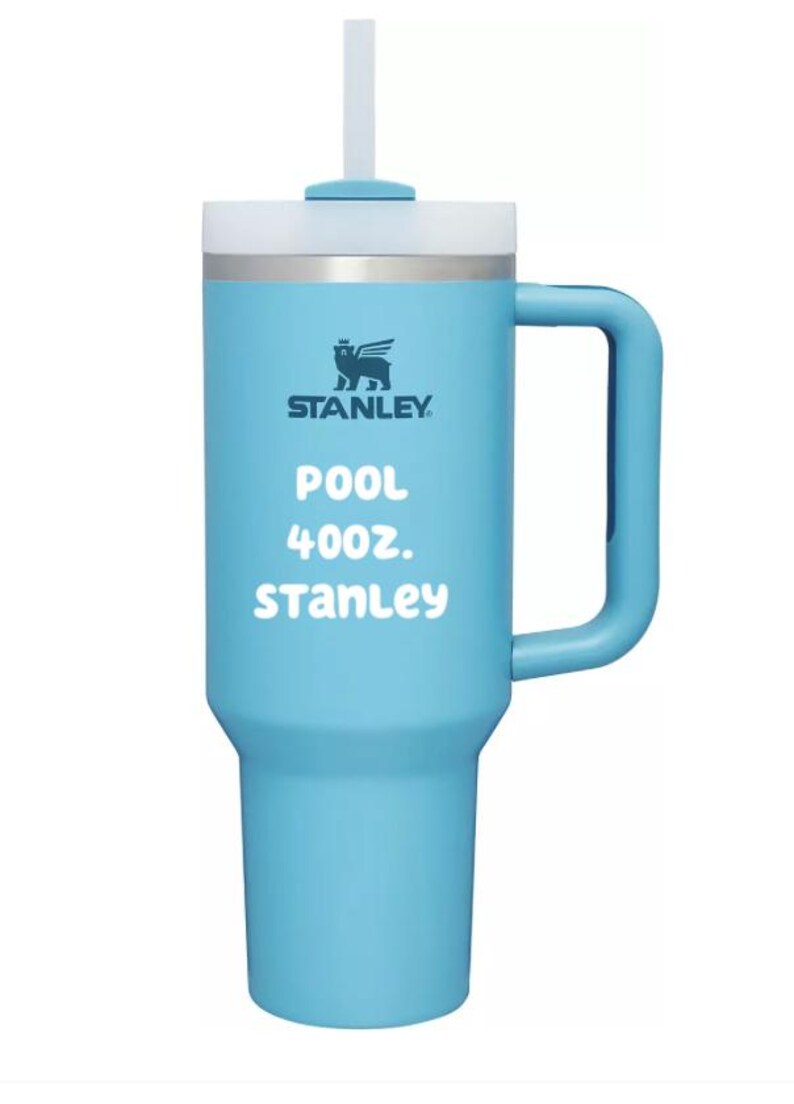 Puede incluir: Un vaso t&eacute;rmico de color azul claro con asa, pajita blanca y tapa. La parte frontal muestra el logotipo de Stanley, el texto POOL, 40oz., y Stanley en letras blancas. El vaso tiene una base c&oacute;nica y un asa vertical en el lado derecho.
