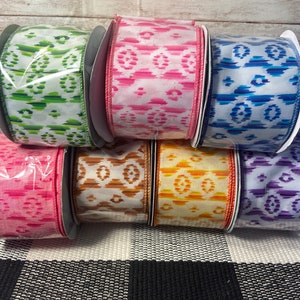 May include: Six rolls of patterned ribbon in various colors, including green, pink, blue, orange, brown, and purple. The ribbon has a geometric design.