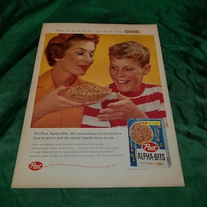 May include: A vintage advertisement for Post Alpha-Bits cereal featuring a mother and son smiling while holding a bowl of the cereal. The ad text reads "It's Post Alpha-Bits - the nourishing cereal mothers love to serve and the whole family loves to eat."  "Pass the good words...and we do mean GOOD."