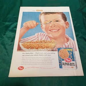May include: A vintage advertisement for Post Alpha-Bits cereal featuring a young boy eating the cereal. The cereal is shaped like letters of the alphabet and the boy is holding a spoon with the word "OATS" spelled out in cereal. The ad copy reads "It's Alpha-Bits... Post's new and nourishing oat cereal your whole family will love." and "All Post Cereals Happen To Be Just A Little Bit Better."