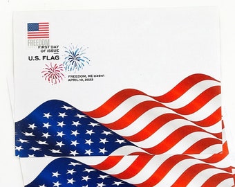 Puede incluir: Cuatro banderas americanas dobladas con rayas rojas y blancas y estrellas azules. Las banderas están dispuestas en una pila, con la bandera superior ligeramente desplazada de las demás. Las banderas están sobre un fondo blanco. El texto "FREEDOM, ME 04941 APRIL 10, 2023" está impreso en la bandera superior.