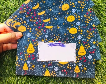 May include: A set of six Halloween-themed envelopes with a dark blue background and a repeating pattern of orange pumpkins, stars, spiderwebs, and skulls. The envelopes have a white label with the text "Please deliver it to:" printed on them.