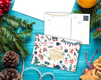 May include: A white Christmas postcard with a colorful pattern of winter-themed illustrations and the text "Merry Christmas". The postcard is surrounded by pine branches, red berries, and gingerbread cookies.