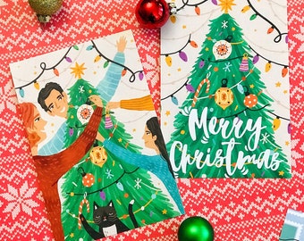 May include: Two Christmas cards with illustrations. One card features a family decorating a Christmas tree with a black cat sitting below. The other card features a decorated Christmas tree with the text "Merry Christmas".