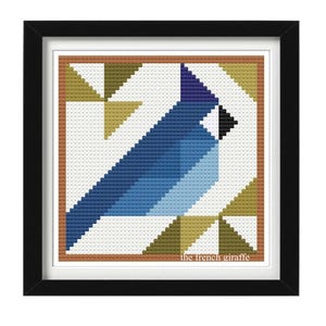 Peut inclure: Un motif d'oiseau géométrique bleu et blanc dans un cadre carré avec une bordure marron. Le fond est blanc avec un motif de triangles jaunes. Le texte "the french giraffe" est en bas du cadre.
