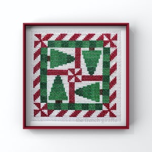 May include: A framed cross-stitch design featuring a red and green pattern with multiple stylized Christmas trees. The design is framed in a red frame.