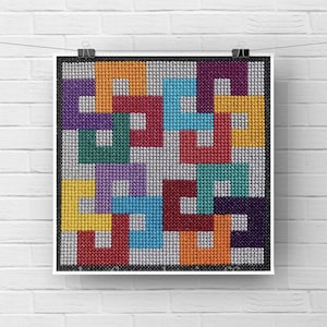 Puede incluir: Un patrón geométrico abstracto colorido con cuadrados en tonos de rojo, naranja, amarillo, verde, azul, morado y blanco. El patrón se crea utilizando una técnica de punto de cruz.