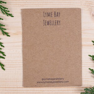 May include: A brown card with the text "LYME BAY JEWELLERY" printed in black. The card also includes the text "@lymebayjewellery" and "www.lymebayjewellery.com" printed in purple.