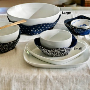 May include: Set of five white ceramic bowls in various sizes, each with a blue and white patterned fabric bowl cozy. The bowls are labeled 'Large', 'Medium', 'Small', 'Small', and 'Extra Small'.